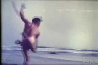 Beautiful vintage boy wanders the beach in the nude
